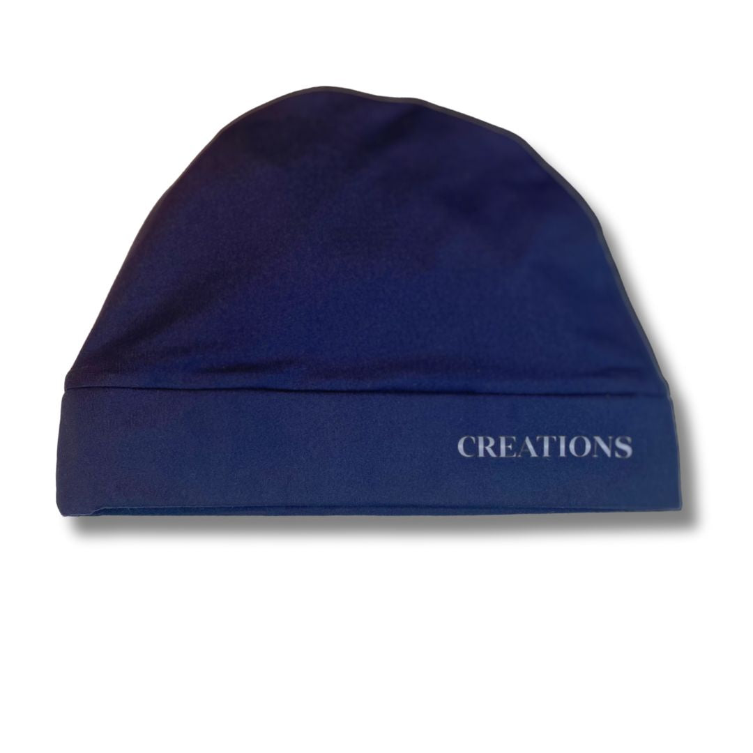 A blue satin lined beanie with the word 'CREATIONS' written on the band.
