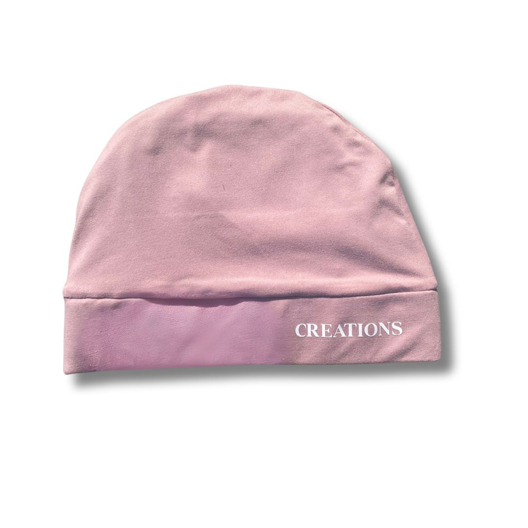 Pink beanie with 'CREATIONS' text on a white background