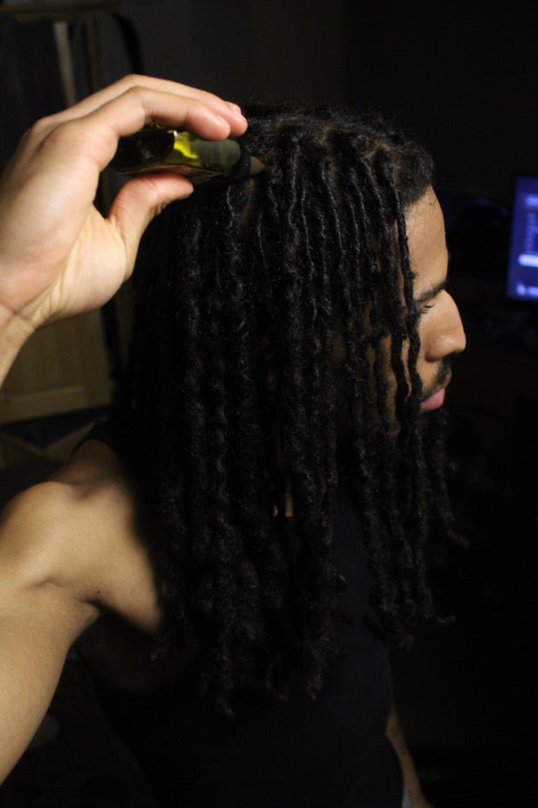 man oiling scalp for hair growth