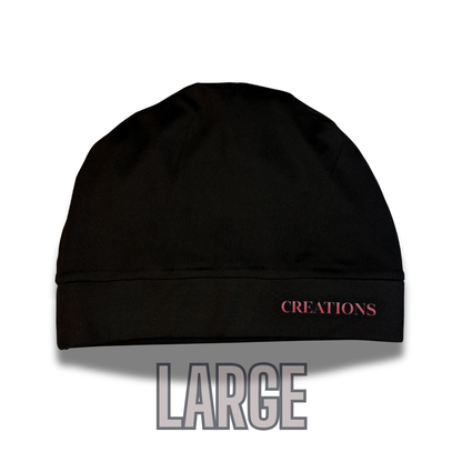 Black beanie with pink 'CREATIONS' branding on a white background
