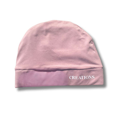 Pink beanie with 'CREATIONS' text on a white background